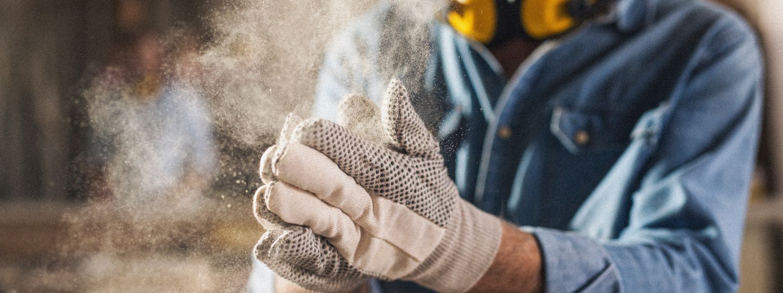 Nahaufnahme von Händen, die einen Versandkarton mit einem Handabroller und braunem Klebeband professionell verschließen